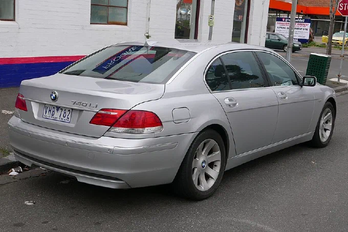 A silver BMW 740Li sedan photographed from behind and to one side, parked at a kerb.